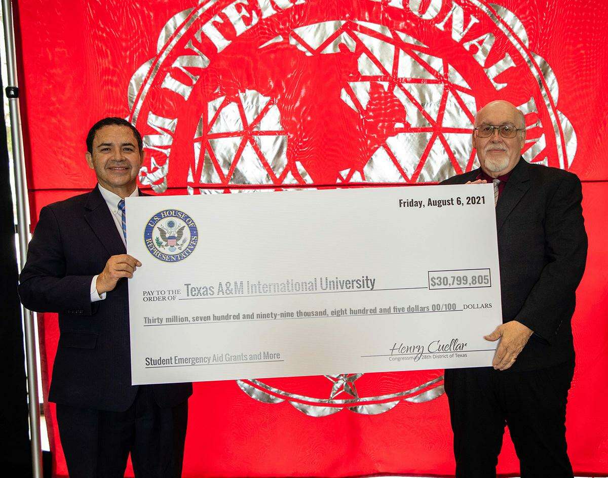 Rep. Henry Cuellar joins TAMIU president Dr. Pablo Arenaz in presenting $30,799,805 in federal grants for TAMIU and its students Friday at the Sue and Radcliffe Killam Library.