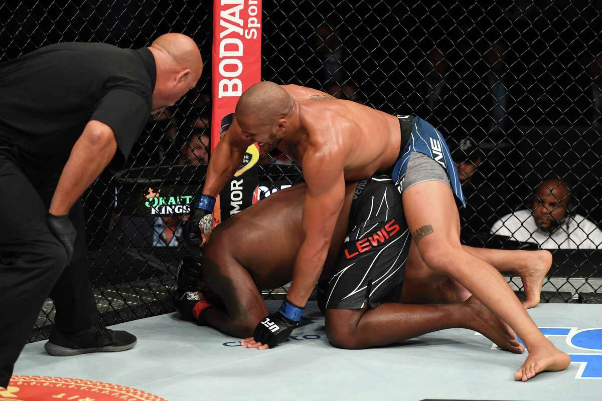 Ciryl Gane of France punches Derrick Lewis in their interim heavyweight title bout during the UFC 265 event at Toyota Center on August 07, 2021 in Houston, Texas