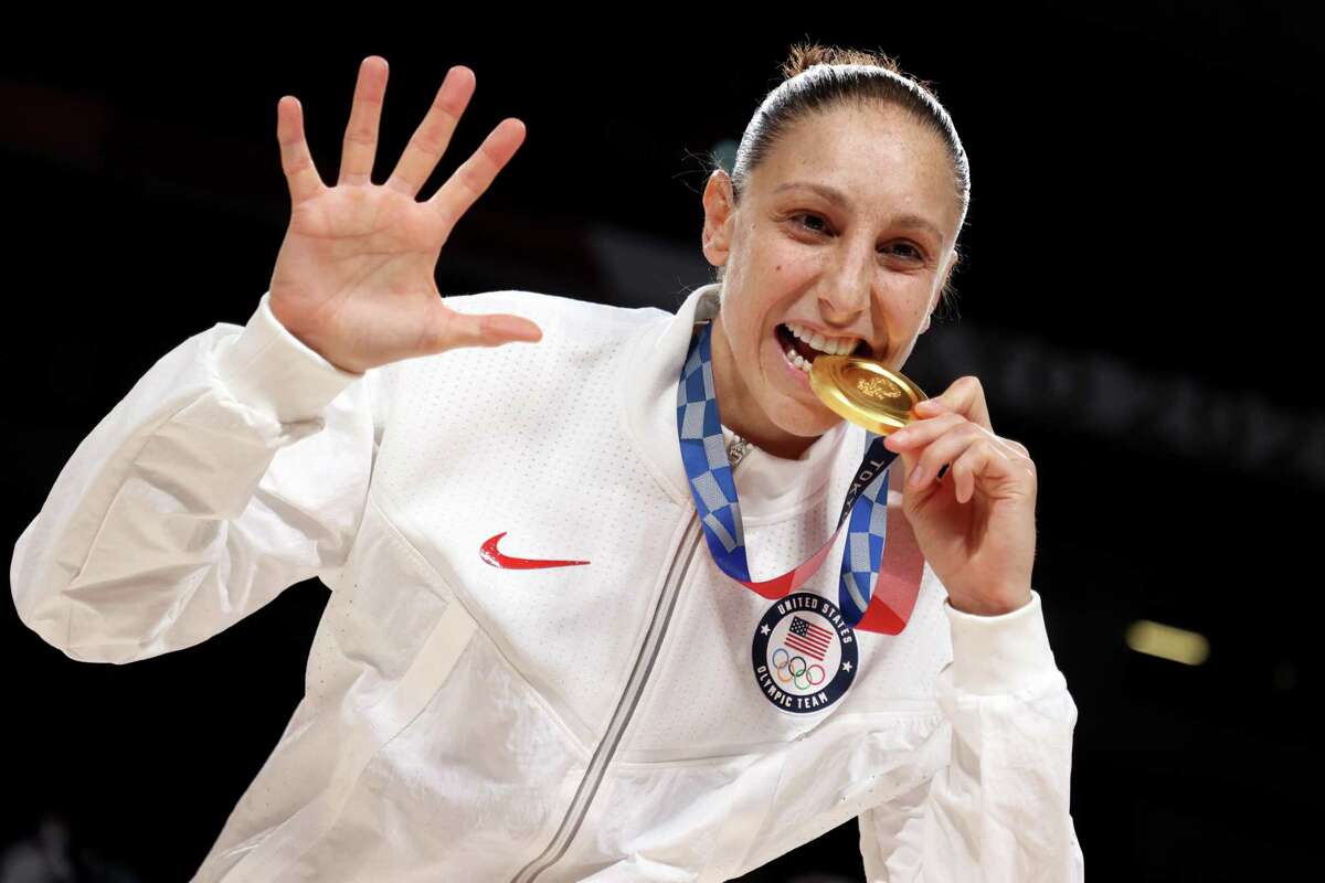SAITAMA, JAPAN - AUGUST 08: Diana Taurasi #12 of Team United States bites her gold medal during the Women's Basketball medal ceremony on day sixteen of the 2020 Tokyo Olympic games at Saitama Super Arena on August 08, 2021 in Saitama, Japan. (Photo by Gregory Shamus/Getty Images)