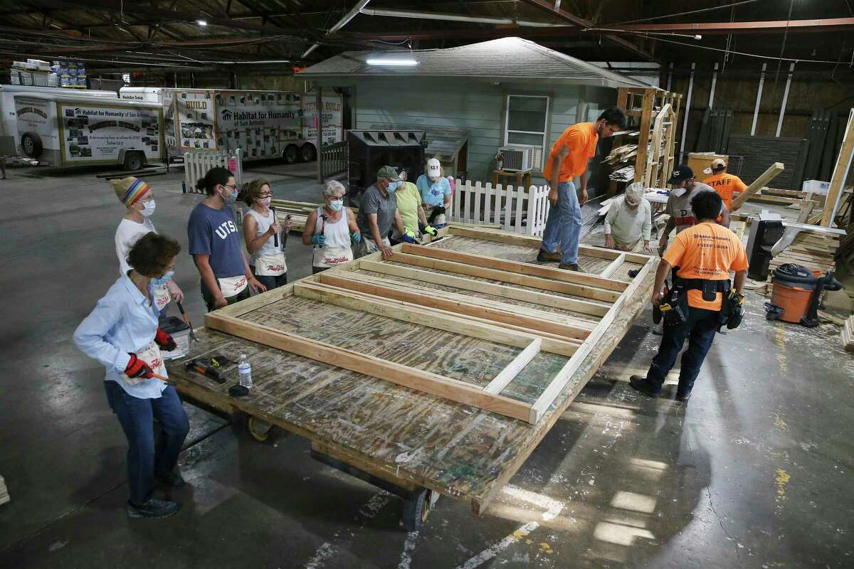 Volunteers from gather to help build a door frame at Habitat for Humanity of San Antonio.