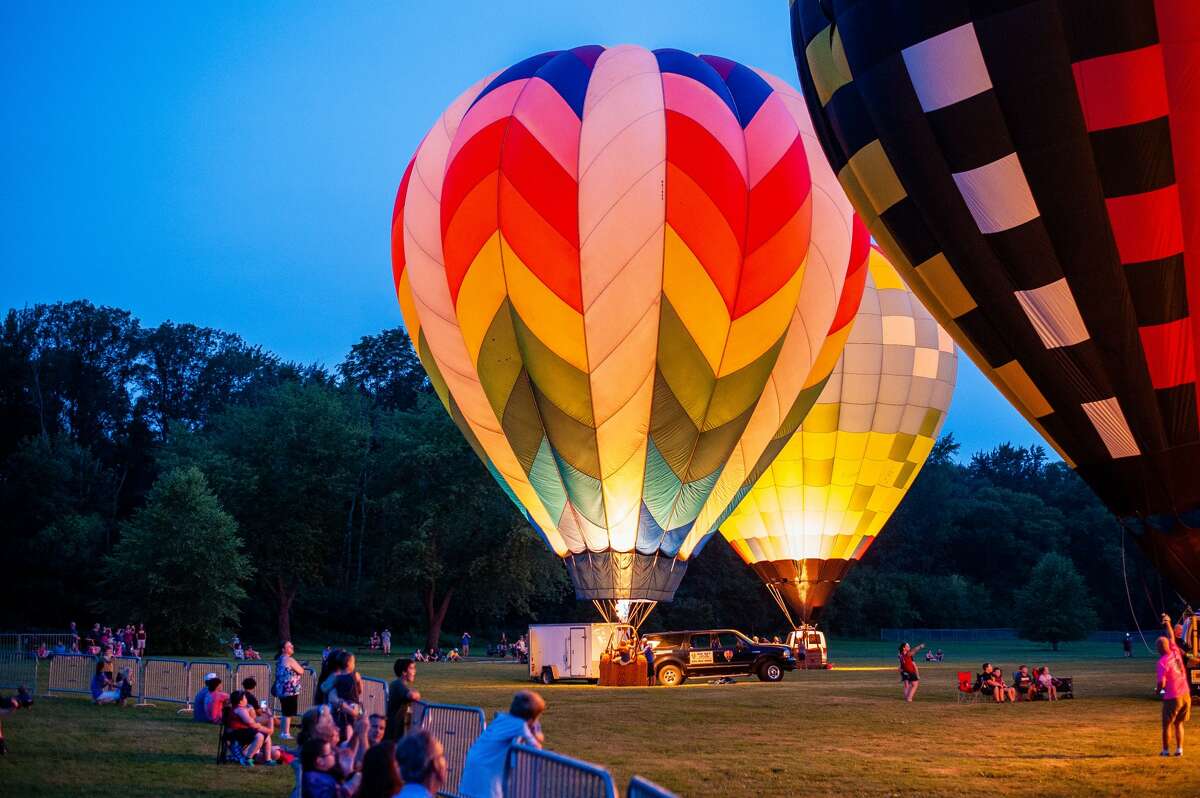 People gather at Chippewassee Park to watch the Amazing Balloon Glow at the River Days Festival on Aug. 7, 2021.