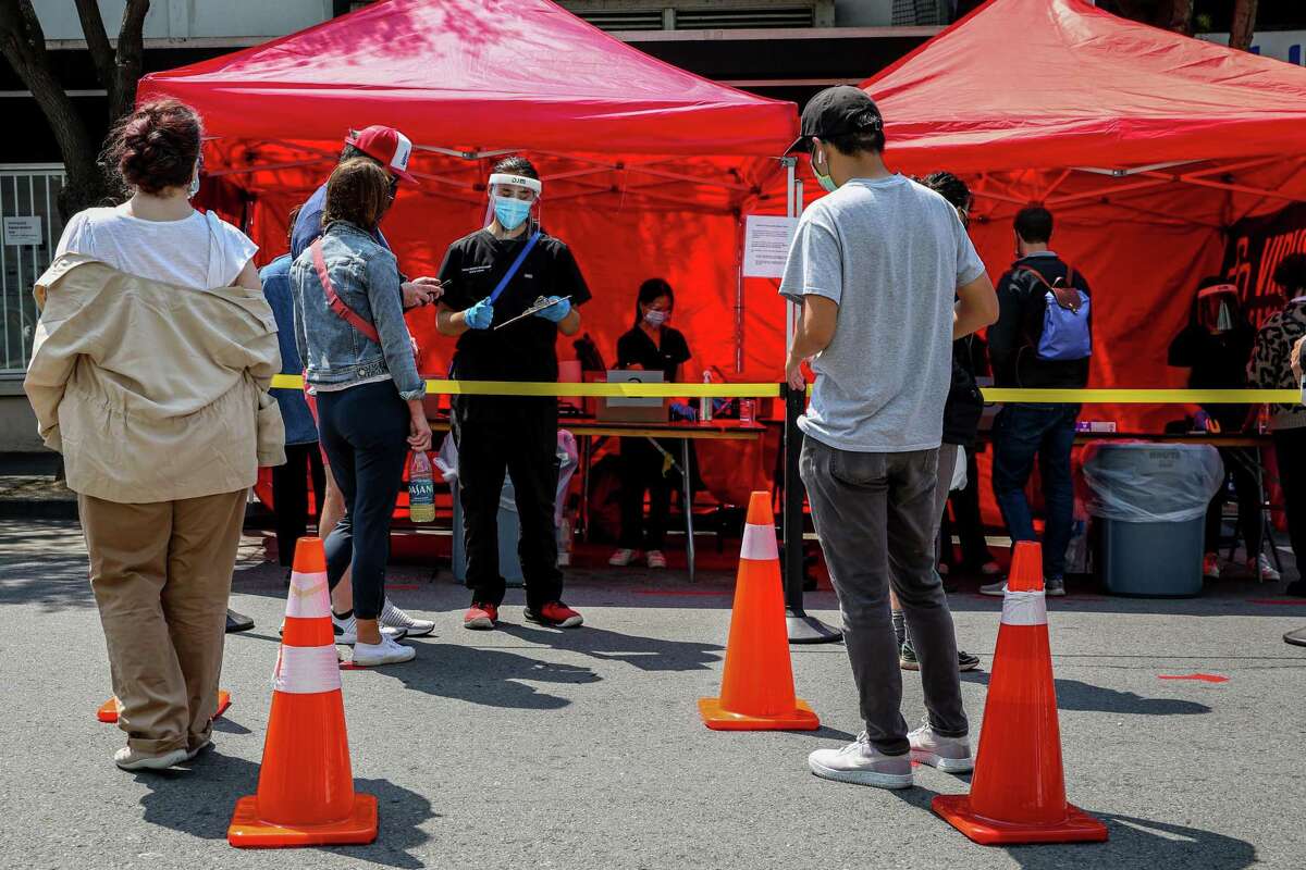A line forms outside a COVID-19 testing tent during the annual Nihonmachi Street Fair in San Francisco, Calif.