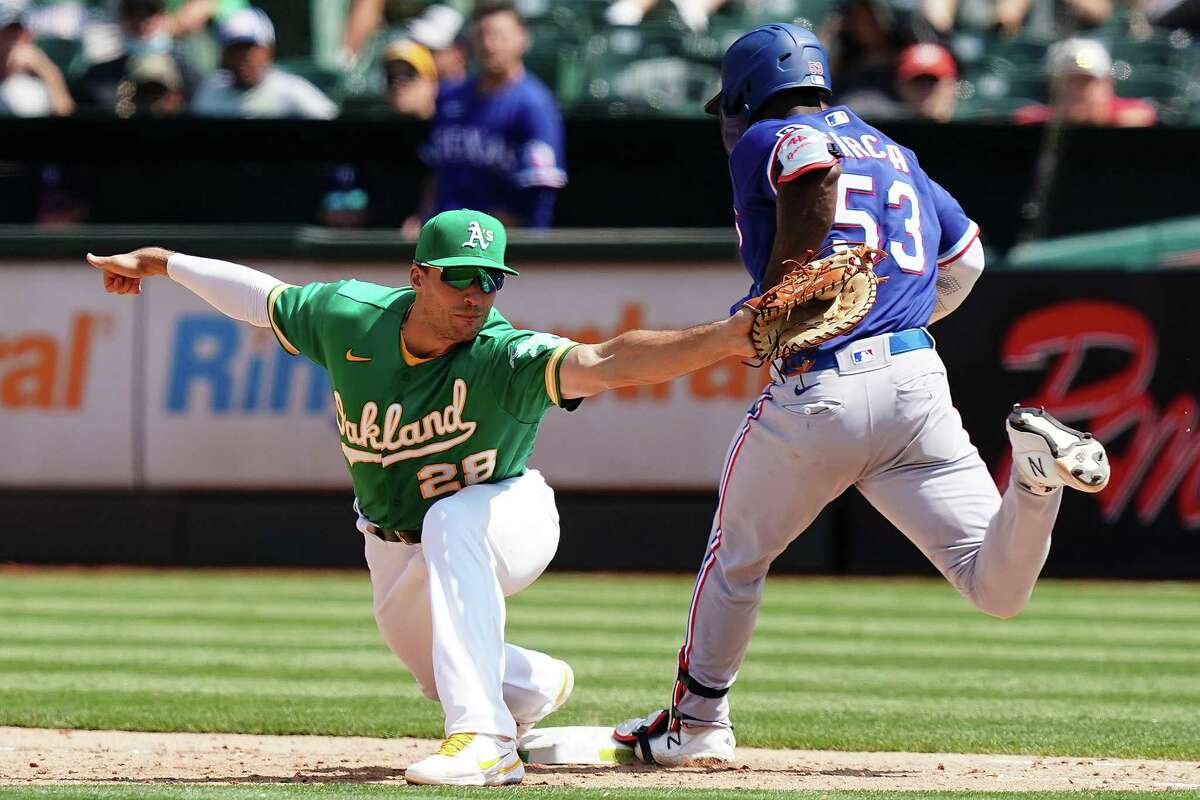 OAKLAND, CALIFORNIA - AUGUST 08: Matt Olson #28 of the Oakland Athletics forces Adolis Garcia #53 of the Texas Rangers out at first during the sixth inning at RingCentral Coliseum on August 08, 2021 in Oakland, California. (Photo by Ben Green/Getty Images)