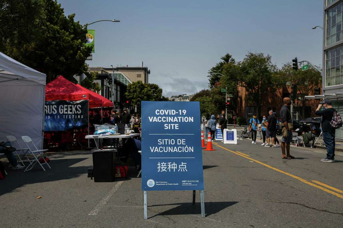 A sign directs people to a vaccination site and and testing tent during the annual Nihonmachi Street Fair in San Francisco.