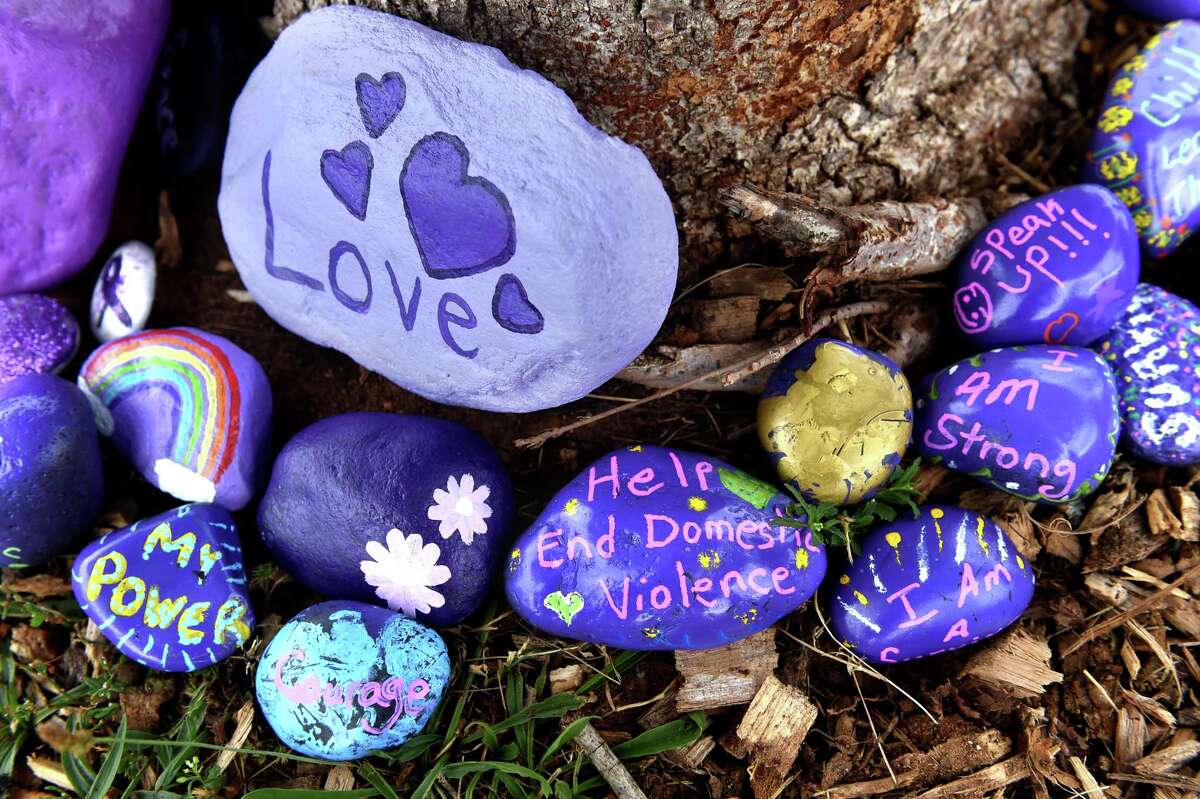 Stones with messages of inspiration surround a tree that was dedicated at an event, Hope Grows Here, to victims of domestic violence by the Hope Family Justice Center at the Quinnipiac River Park in New Haven on Aug. 9, 2021. The messages were painted by victims of domestic violence, their children, family and friends and staff of the Hope Family Justice Center.