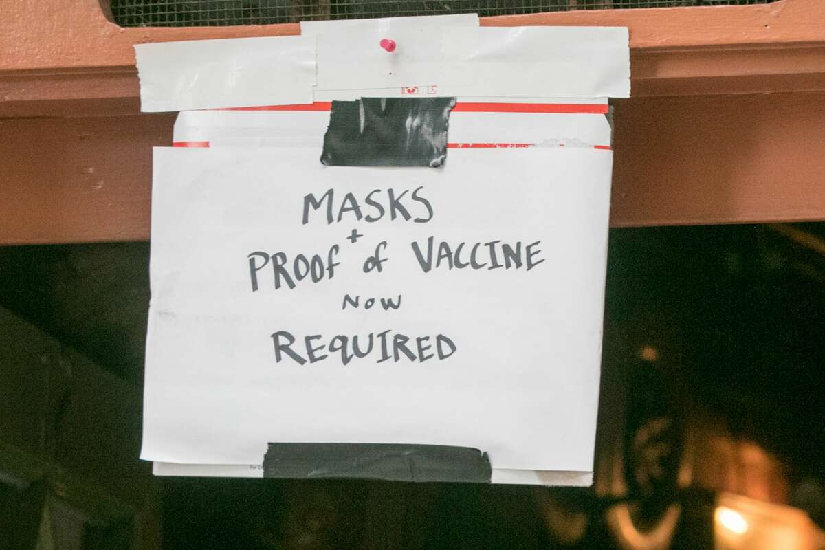 A sign outside Specs Bar reminds customers that proof of shots and masks are required, in San Francisco on August 5, 2021.