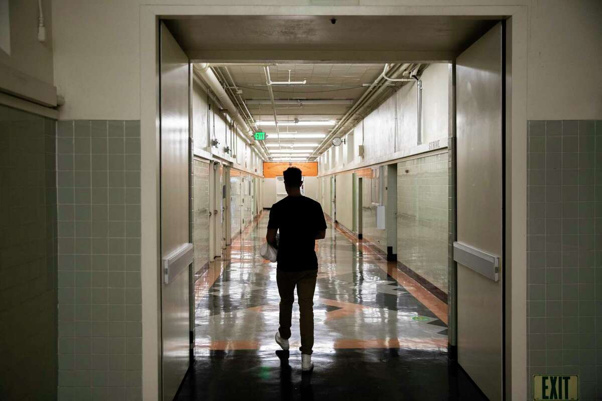 Braden DeWitt walks to his classroom to prepare it for physical distancing at McClymonds High School in Oakland, Calif.