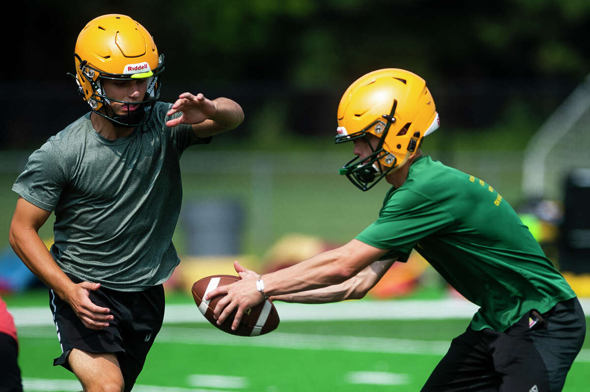 Dow's Dawson Studebaker, right, fakes a hand-off to Caden Chritz, left, during the Chargers' first football practice of the year Monday, Aug. 9, 2021 at H. H. Dow High School. (Katy Kildee/kkildee@mdn.net)