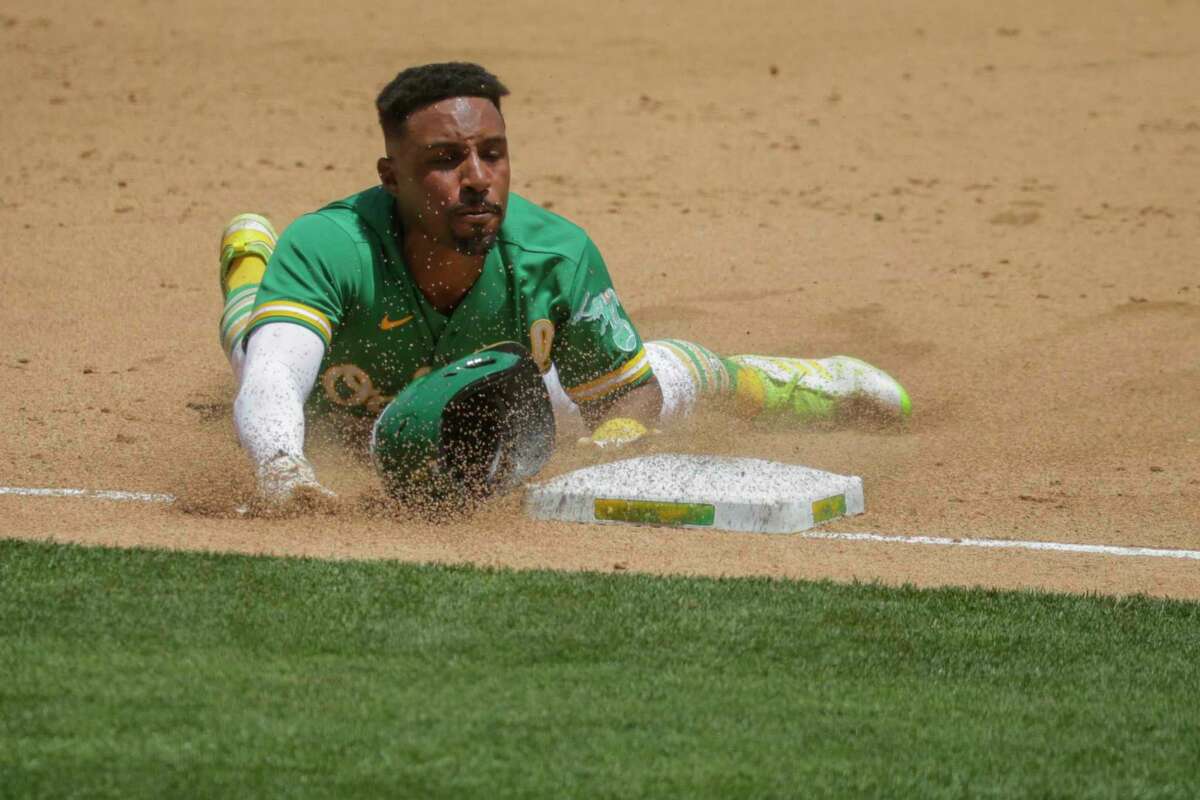 Tony Kemp (5) slides to third during the bottom of the fifth inning as the Oakland Athletics played the Los Angeles Angels at the Coliseum in Oakland, Calif. Wednesday, June 16, 2021. The A?•s defeated the Angels 8-4.