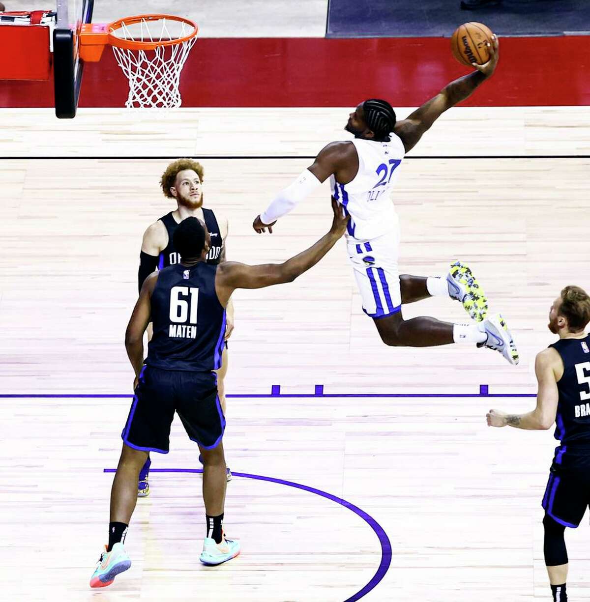 The Warriors’ Cameron Oliver leaps for a dunk against the Orlando Magic’s Yante Maten (61) and Hassani Gravett.