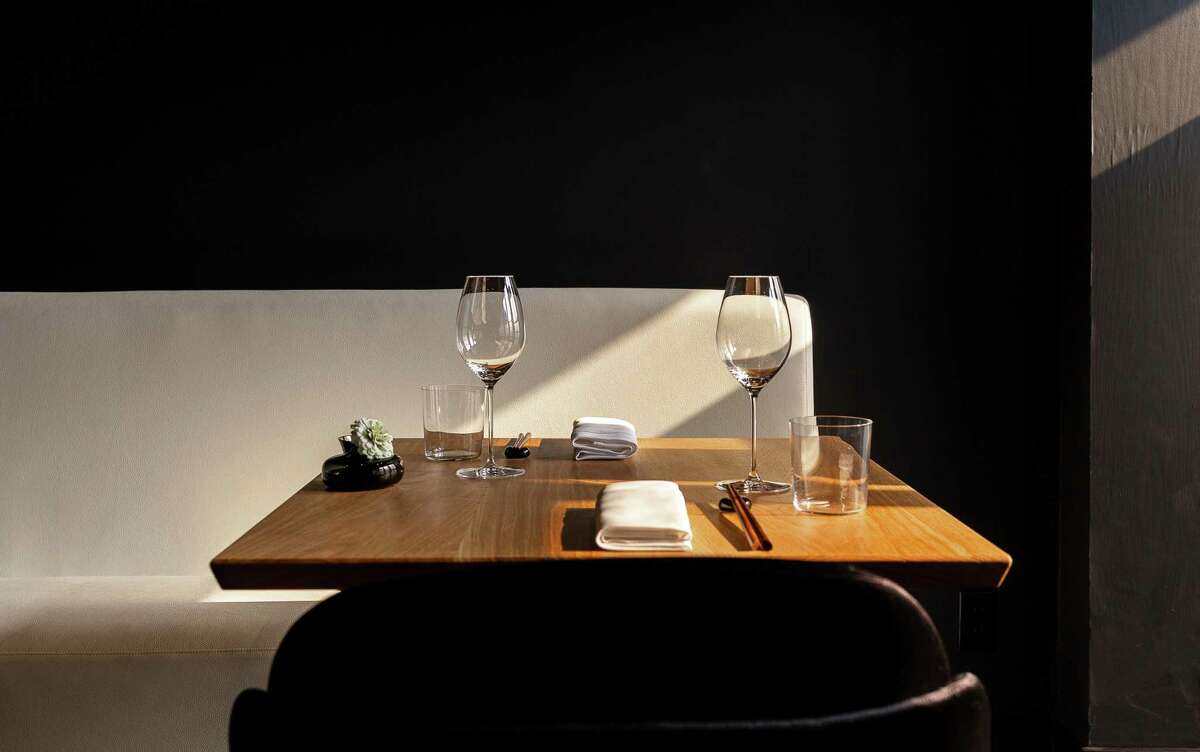 The dining room at Restaurant Nisei in San Francisco features handmade oak tables and a black-and-white color scheme.