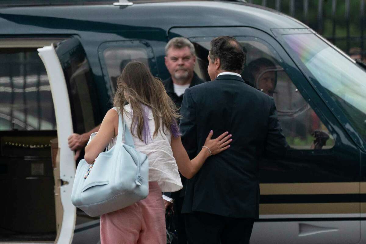Michaela Cuomo, Andrew Cuomo's daughter, left, rests her hand on the back of her father, New York Gov. Andrew Cuomo as they take a helicopter flight from a Manhattan heliport, Tuesday, Aug. 10, 2021 in New York. Cuomo says he will resign over a barrage of sexual harassment allegations. The three-term Democratic governor's decision, which will take effect in two weeks, was announced Tuesday as momentum built in the Legislature to remove him by impeachment.