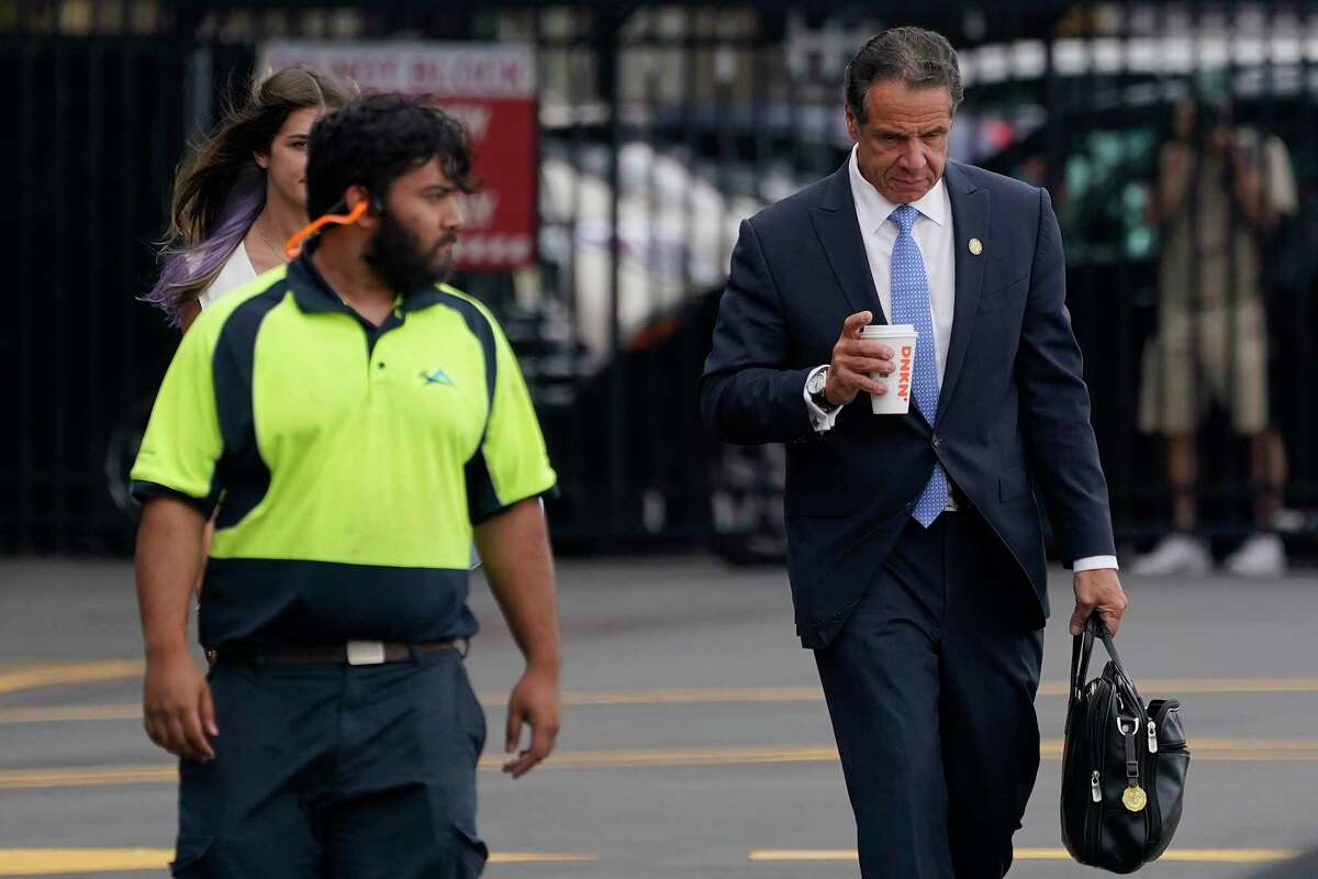 New York Gov. Andrew Cuomo, right, prepares to board a helicopter after announcing his resignation, Tuesday, Aug. 10, 2021, in New York. Cuomo says he will resign over a barrage of sexual harassment allegations. The three-term Democratic governor's decision, which will take effect in two weeks, was announced Tuesday as momentum built in the Legislature to remove him by impeachment.