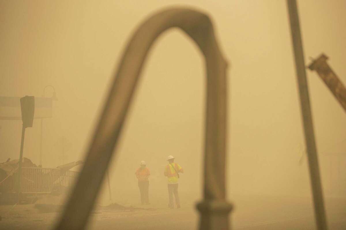 CalTrans workers inspect a road for damages during the Dixie Fire in Greenville, Calif.
