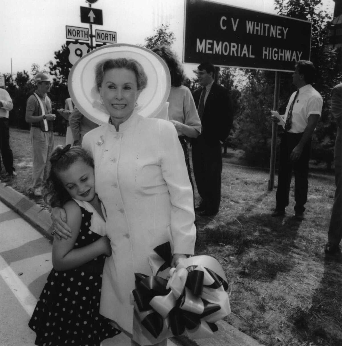 Route 50 at Broadway, Saratoga Springs, New York - Kristine Schlachter, 8, hugs her grandmother, Mary Lou Whitney, following a ceremony renaming the Route 50 arterial in Saratoga Springs the C.V. Whitney Memorial Highway in honor of Mary Lou's husband, Sonny Whitney. August 09, 1994 (Paul D. Kniskern/Times Union Archive)