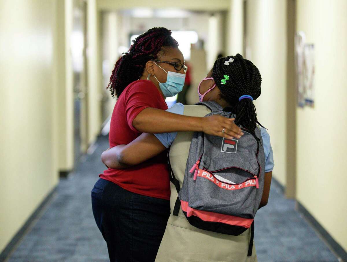 Chandra Hutto, Heflin Elementary librarian, greets a student on the first day of school on Tuesday, Aug. 10, 2021, in Houston.