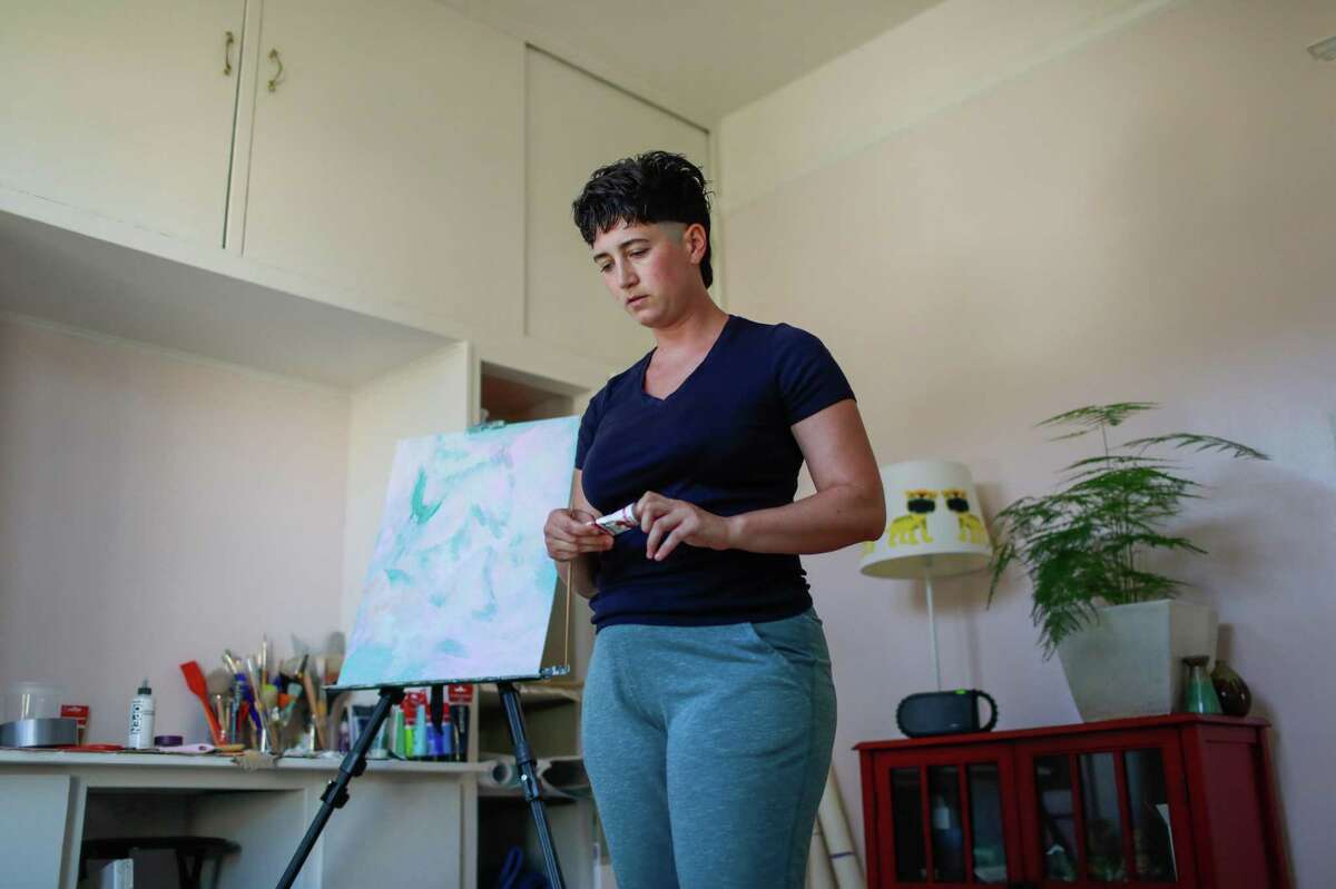 Jasper Wilde works on a sign for Pride in her apartment on Thursday, June 24, 2021, in San Francisco, Calif. Wilde has struggled to access unemployment benefits and rent relief, and is among a group of tenant activists considering other tactics to keep from being evicted.