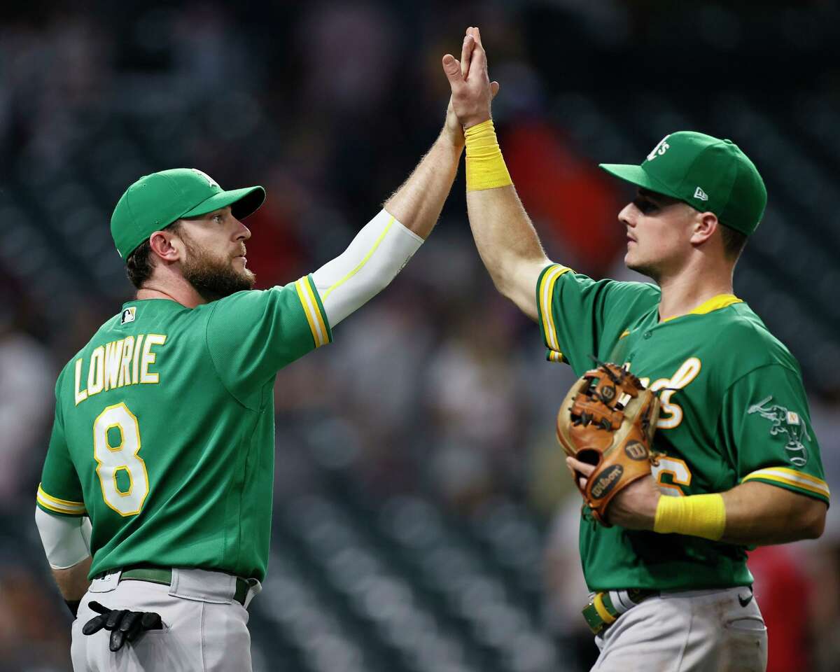 CLEVELAND, OH - AUGUST 10: Jed Lowrie #8 and Matt Chapman #26 of the Oakland Athletics celebrate a 4-3 victory over the Cleveland Indians in 10 innings at Progressive Field on August 10, 2021 in Cleveland, Ohio. (Photo by Ron Schwane/Getty Images)