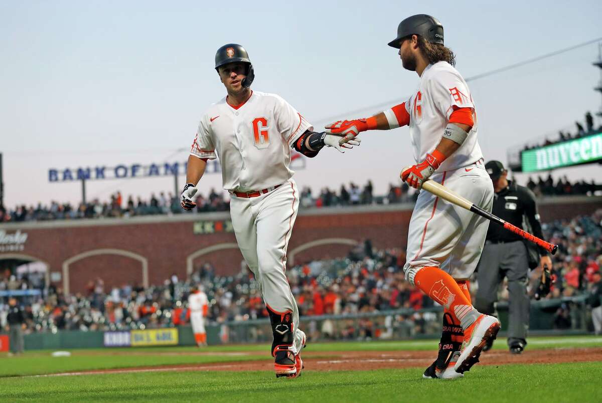 San Francisco Giants' Buster Posey slaps hands with Brandon Crawford after hitting solo home run off of Arizona Diamondbacks' Zac Gallen in 5th inning during MLB game at Oracle Park in San Francisco, Calif., on Tuesday, August 10, 2021.