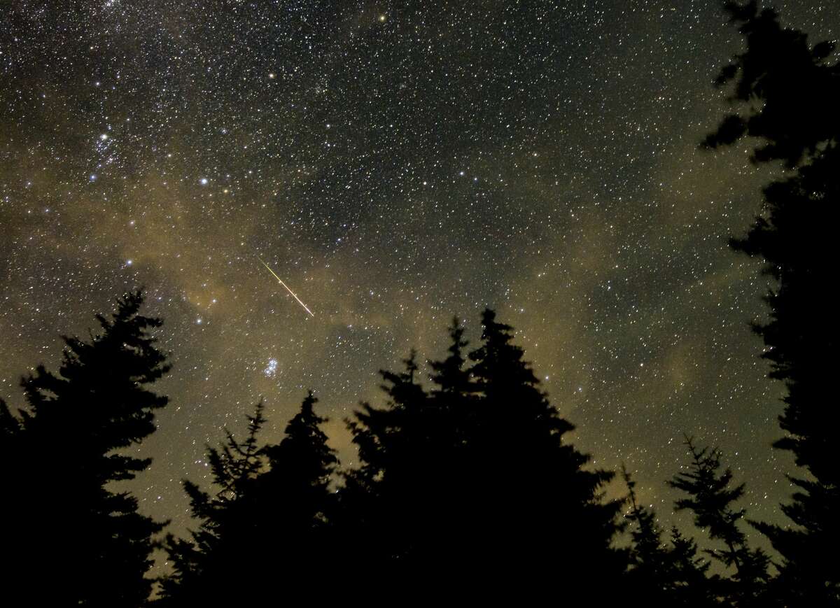 In this 30 second exposure, a meteor streaks across the sky during the annual Perseid meteor shower, Wednesday, Aug. 11, 2021, in Spruce Knob, West Virginia. 