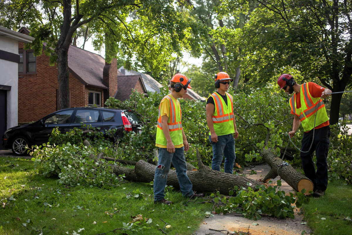 Midland residents work to remove storm debris from their homes, sidewalks and streets Wednesday, Aug. 11, 2021 after a severe thunderstorm the night before. (Katy Kildee/kkildee@mdn.net)
