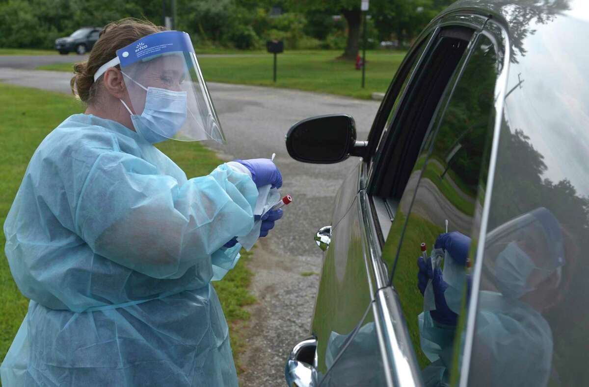 Heidi Bettcher, RN, Public Health Nurse, collects a self administered COVID test swab during the first day of the New Milford Health Department's COVID-19 drive-thru testing site at John Pettibone Community Center. Wednesday, August 11, 2021, New Milford, Conn.