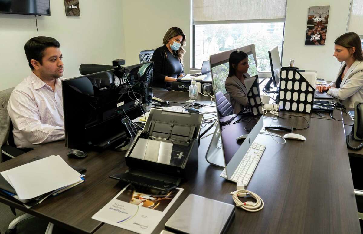 (LtoR) Sadiq Wahid, Giovanna Garcia and Guilia Avoltini work in their office, Wednesday, Aug. 4, 2021, at ZT Corporate's Houston office. The company's CEO, Taseer Badar, is pushing to require 100% of his employees to be vaccinated.