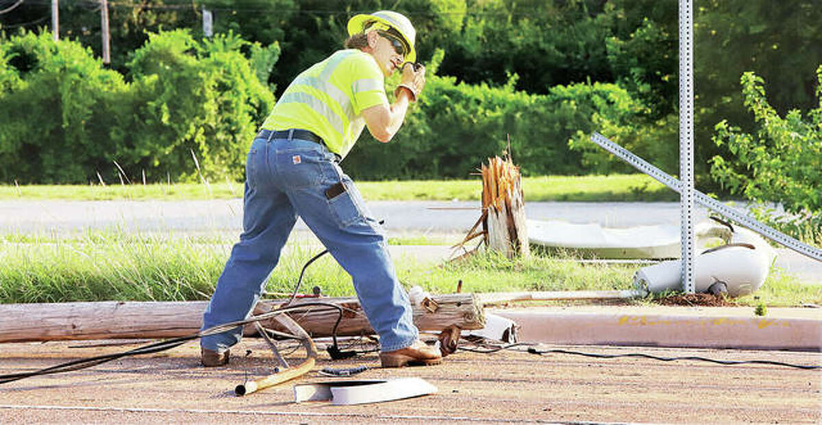 An Ameren worker disconnects power from a downed light pole Wednesday morning after it was struck by a motorist. John Badman|The Telegraph