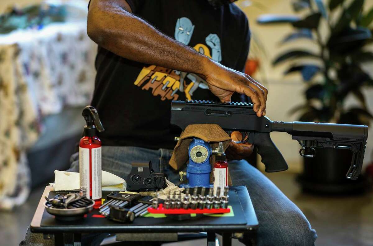 Anthony Dart cleans his rifle in his studio on Friday, June 11, 2021, in Oakland, Calif. The 42-year-old firearms safety instructor says Black Americans face more barriers to exercising their Second Amendment rights than white Americans do.