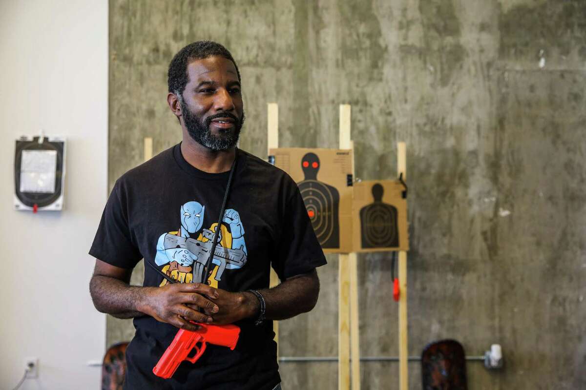 Anthony Dart, a 42-year-old Oakland transplant by way of Vicksburg, Miss., brought his enthusiasm for hunting and shooting to the heart of Fruitvale. Here Dart holds an orange demo gun as he speaks with The Chronicle on Friday, June 11, 2021, in Oakland, Calif. Dart teaches shooting self-defense classes for real-life scenarios -- such as home invasion robberies -- and views guns as a form of empowerment.