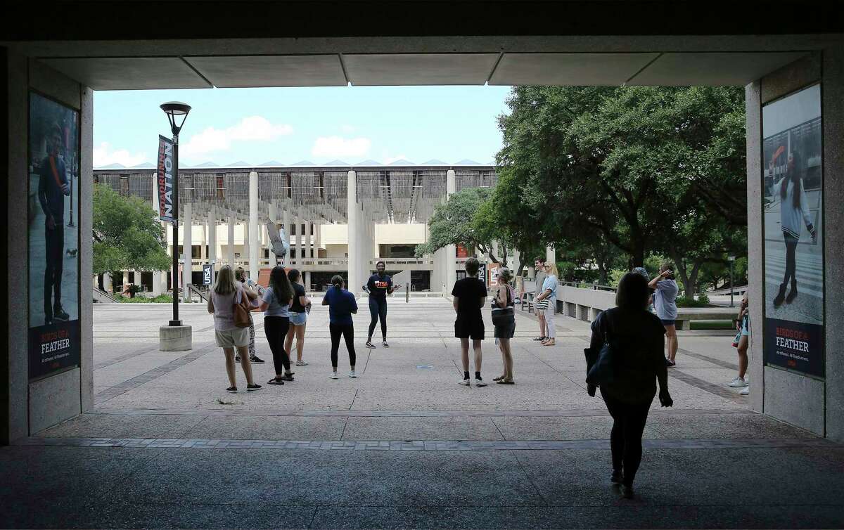 A UTSA ambassador takes visitors on a tour of the campus. The university is delaying the start of in-person classes by three weeks, moving them online.