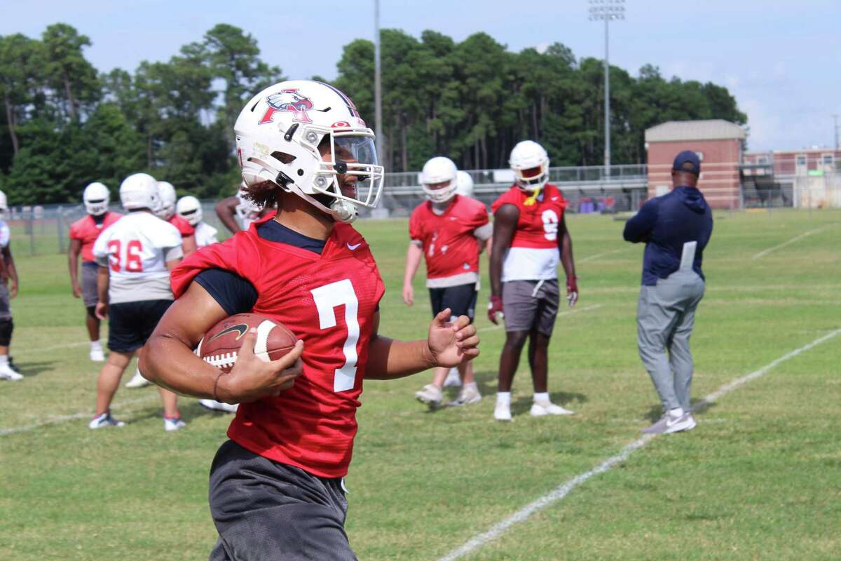 Atascocita quarterback Gavin Session working with coach Craig Stump during drills on the first day of fall camp.