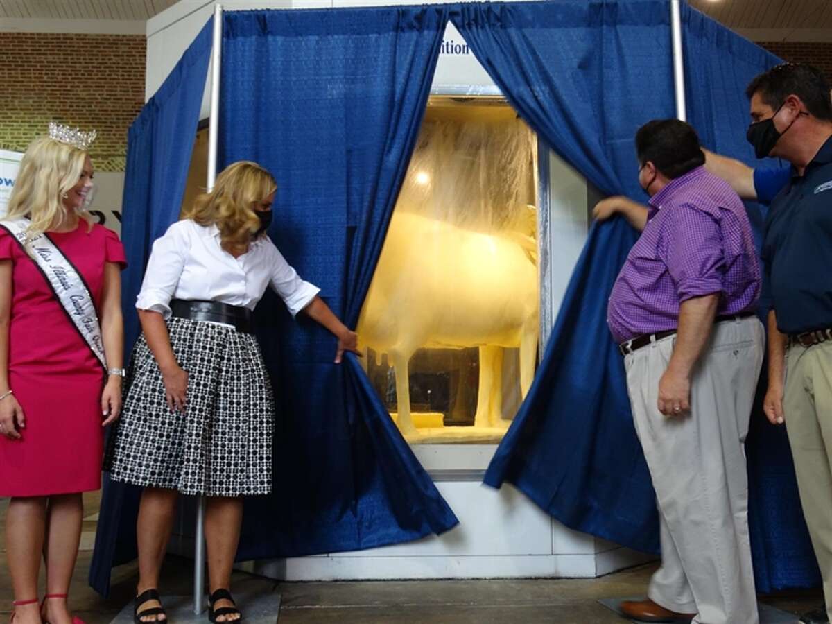 Gov. JB Pritzker and First Lady MK Pritzker unveil the Illinois State Fair's 2021 butter cow, along with Department of Agriculture Director Jerry Costello II, far right, and 2021 Miss Illinois County Fair Queen Kelsi Kessler. (Capitol News Illinois photo by Peter Hancock)