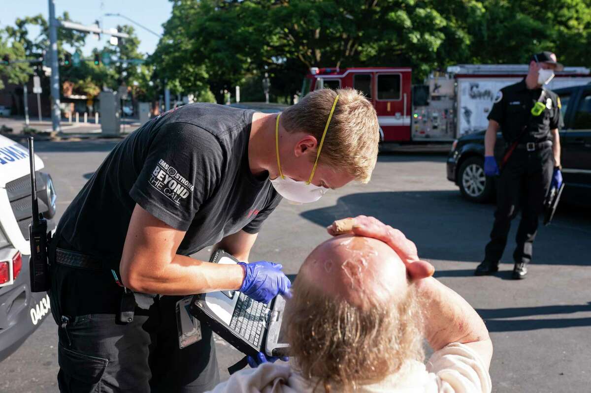 A paramedic treats a man experiencing heat exposure during June’s heat wave in Oregon.