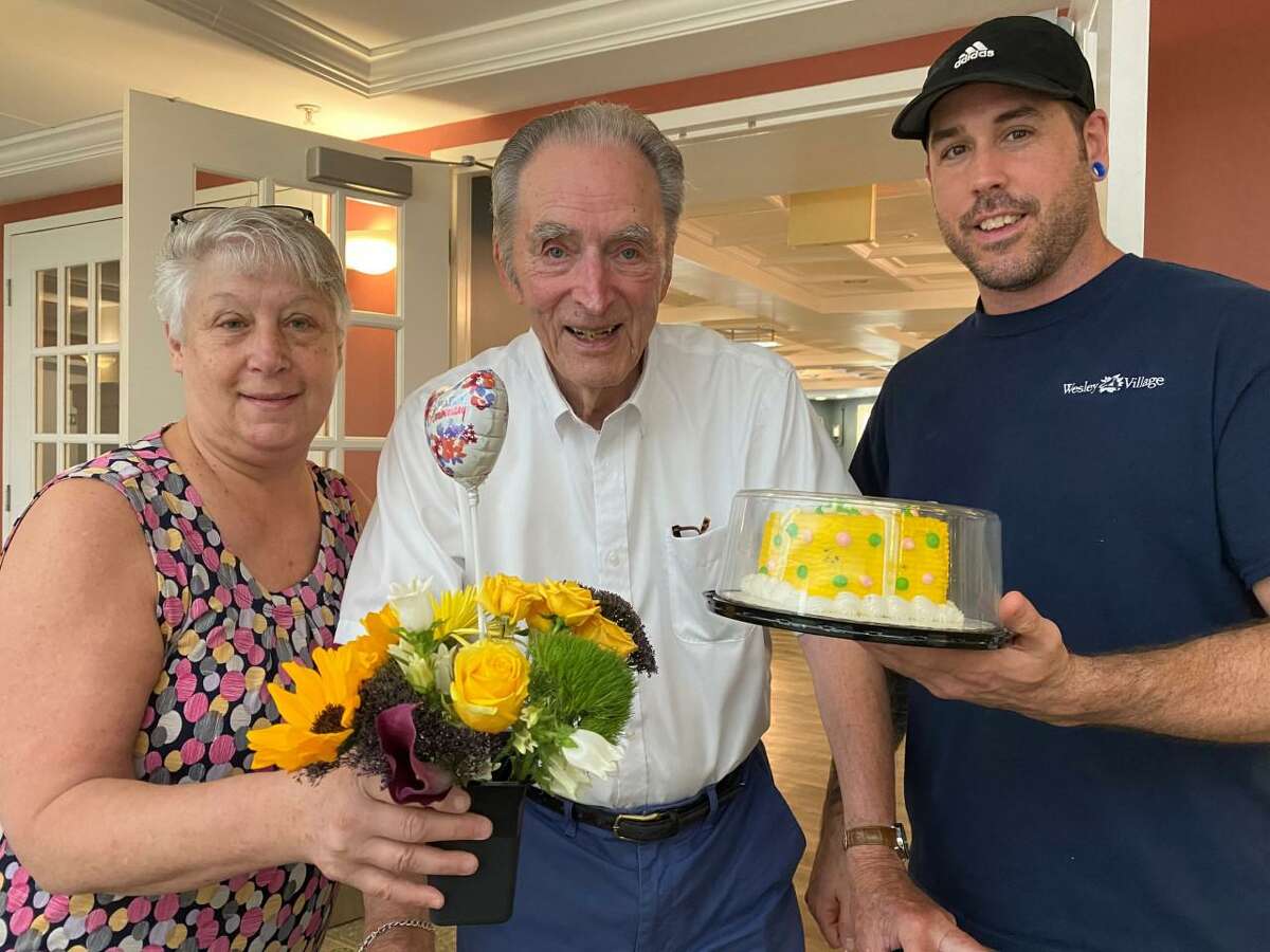 Longtime Wesley Village senior living campus in Shelton residents Ken, and Doris Steeves, recently celebrated their 70th wedding anniversary on Tuesday, July 14. Crosby Commons team members Cathy Brelsford, (left), and Jim Tomchik, (right), pose with Ken, (middle), before a visit to see his wife Doris on their 70th wedding anniversary.