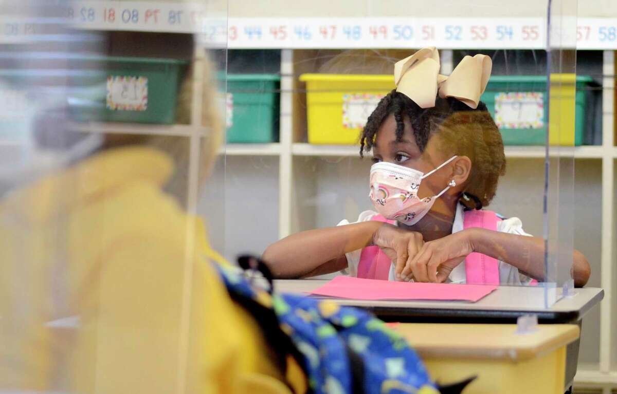 Calise Evans sits behind a plastic enclosure at her desk at Summit Elementary School in Summit, Miss., on Thursday, Aug. 5, 2021. (Matt Williamson /The Enterprise-Journal via AP)