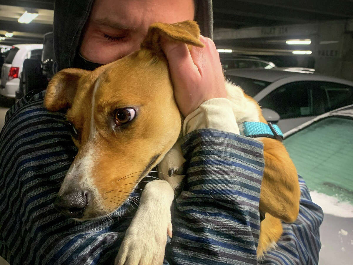 Jonathan Burk hugs his dog, Canela, after they were reunited in Lake Tahoe last winter. Canela was missing for three days. 