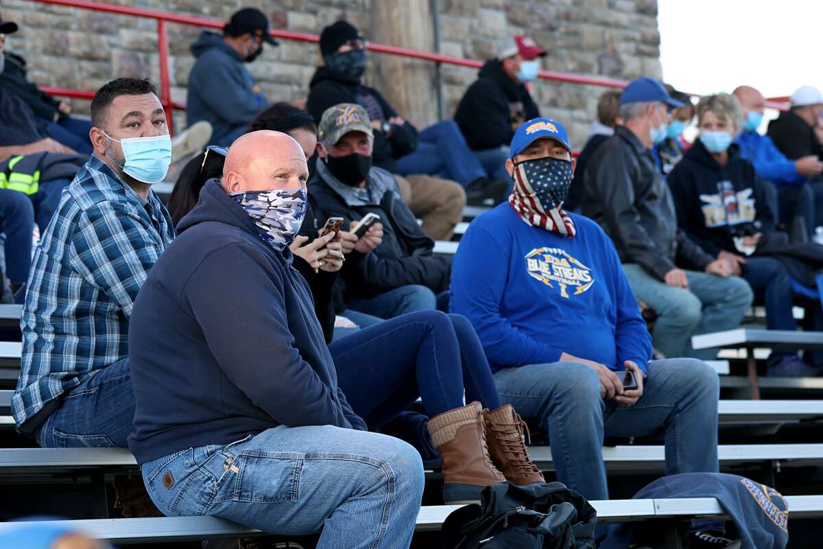 Fans sit in the stands wearing masks during the game between the Ida Bluestreaks and the Clinton Redskins on September 18, 2020 in Clinton, Michigan. (Photo by Justin Casterline/Getty Images)