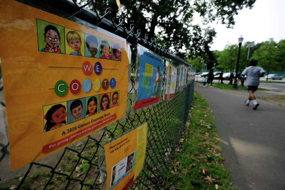 A jogger passes a 2020 Census display on a fence outside the playground at Scalzi Park on Sept. 15, 2020 in Stamford, Conn. The Census report takes place every ten years, counting those living in the United States and in its terrtories: Puerto Rico, American Samoa, the Commonwealth of the Northern Marina Islands, Guam, an the U.S. Virgin Islands.