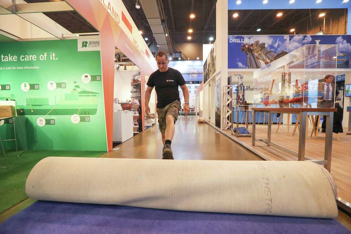 Rigo ( he only goes by one name ) from Germany rolls up carpet in front of his exhibits at the end of the Offshore Technology Conference Thursday, May 9, 2019, in Houston.