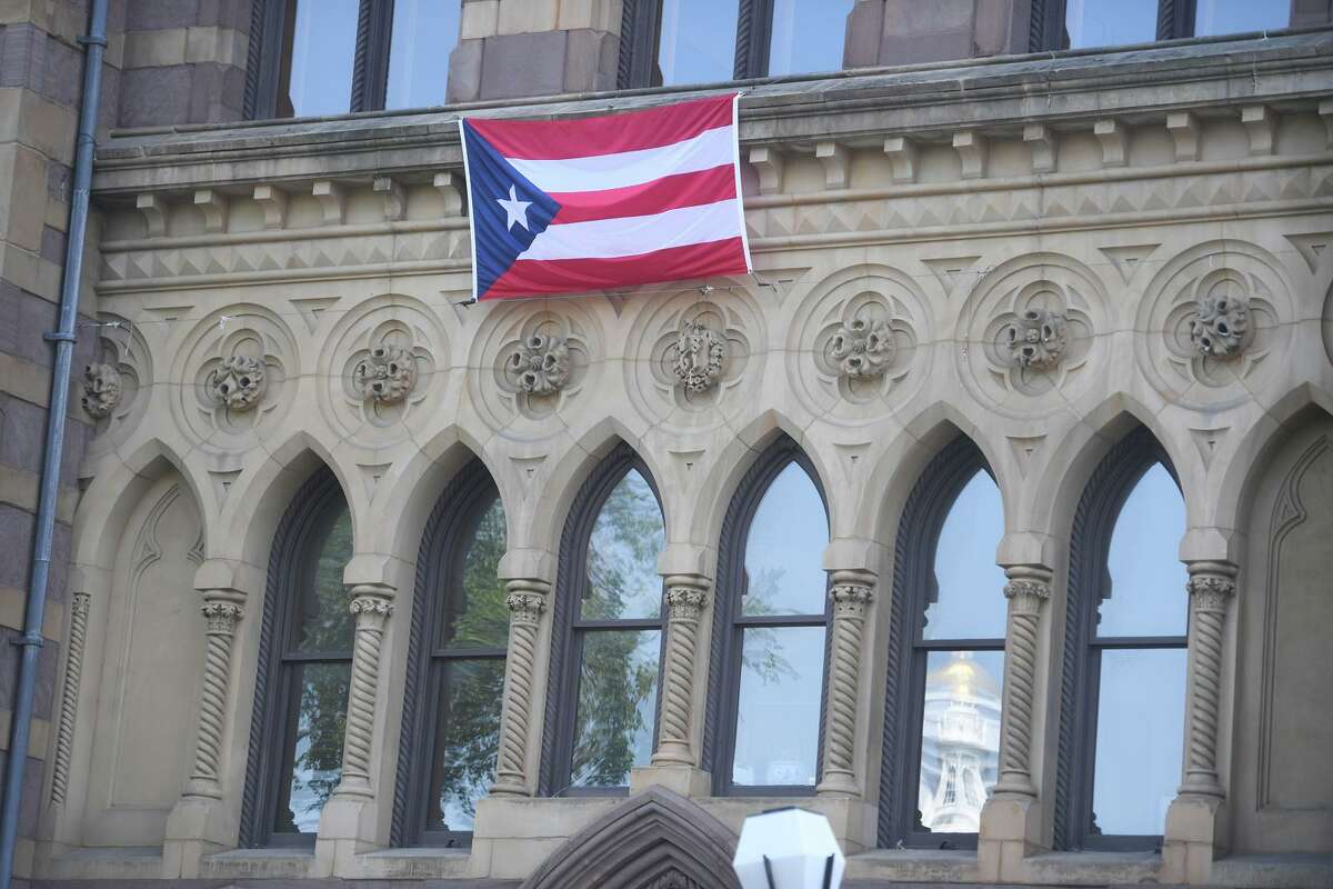 The Puerto Rican flag hangs on New Haven City Hall in honor of the city's Puerto Rican community, one of the country's largest, in New Haven, Conn. on Thursday, August 12, 2021.