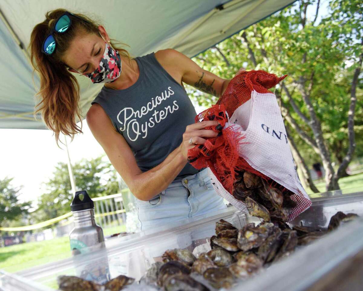Precious Oysters owner Rachel Precious arranges her oysters on the opening day of the Hey Stamford! Food Festival at Mill River Park in Stamford, Conn. Thursday, Aug. 12, 2021.
