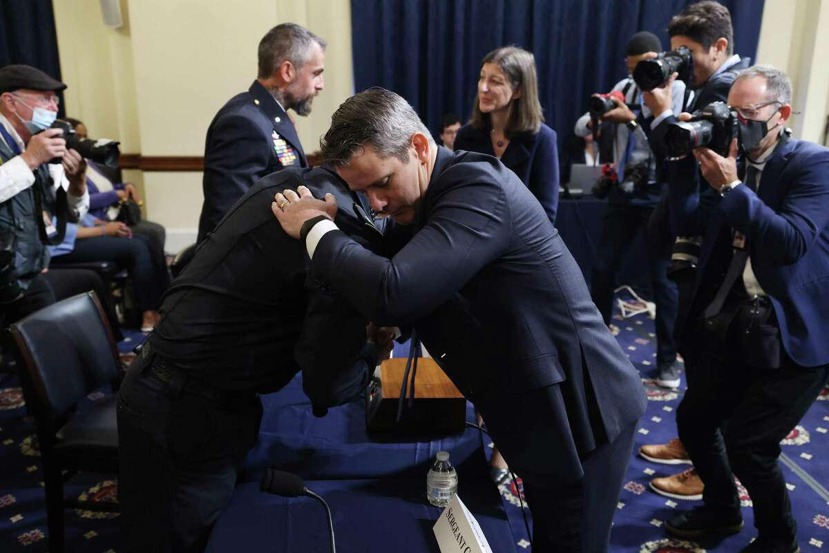 Rep. Adam Kinzinger, R-Ill., right, embraces a Capitol police officer July 27. Kinzinger has stayed true to the tenets of his military service; the same can’t be said for his GOP colleagues.
