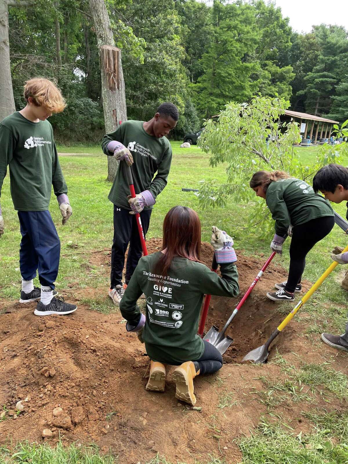Teens in the Greenwich Youth Conservation Program dig a hole for a tree for one of their many summer projects in 2021.