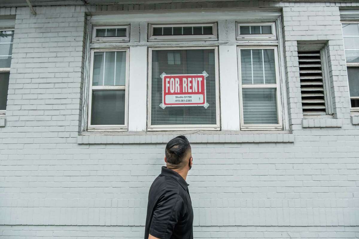 A pedestrian looks up at a “For Rent” sign in a window on Hayes Street in San Francisco on Friday, October 9, 2020.