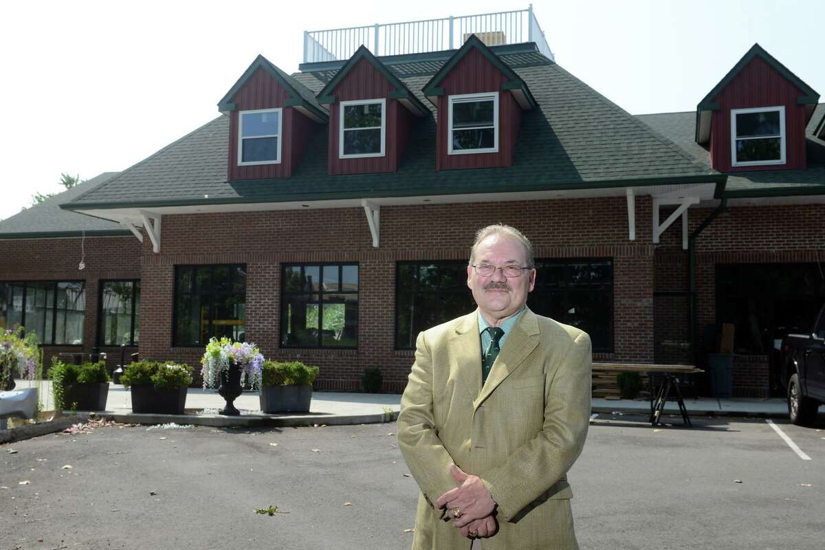 Developer John Guedes poses in front of the Riverside Retail Center in Shelton, Conn. Aug. 11, 2021.