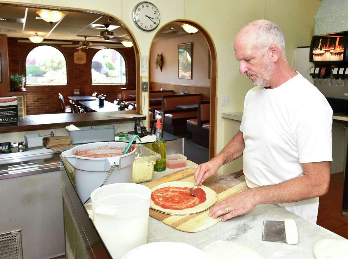 NEW HAVEN, Κονέκτικατ - Παρασκευή, 13 Αυγούστου 2021: Ο ιδιοκτήτης της πιτσαρίας Ernie's Pat DeResso ετοιμάζει πίτσα στην ανοιχτή κουζίνα του εστιατορίου.  Μια από τις καλύτερες και πιο διάσημες πιτσαρίες στο New Haven, η Ernie's Pizzeria βρίσκεται στο Westville και λειτουργεί από το 1971. Η Ernie's Pizzeria γιορτάζει τα πενήντα της χρόνια αυτόν τον μήνα.