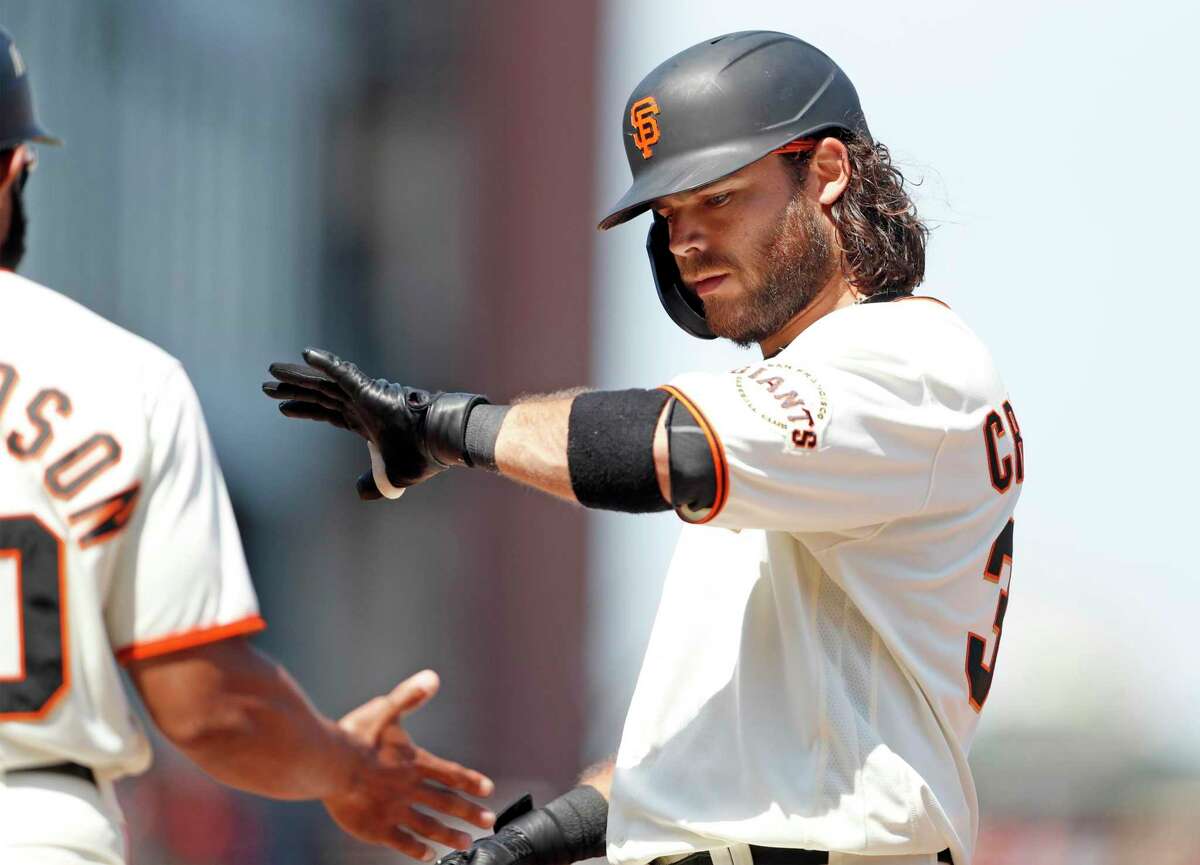 San Francisco Giants' Brandon Crawford slaps hands with first base coach Antoan Richardson after his 6th inning RBI single that gave the Giants a 7-6 lead over Houston Astros during 8-6 win in MLB game at Oracle Park in San Francisco, Calif., on Saturday, July 31, 2021.