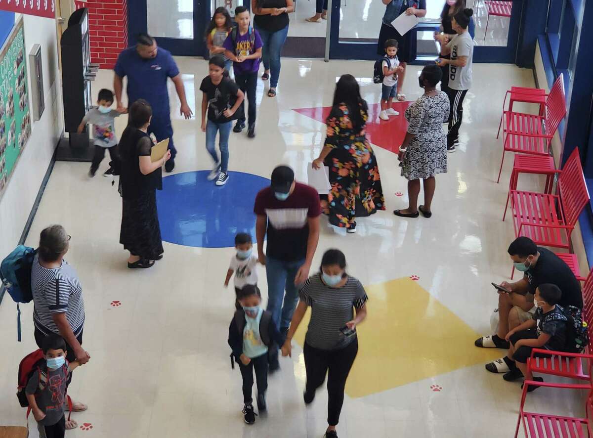 Students and parents file past Converse Elementary School staff on July 26, the Judson ISD campus’ first day on a year-round calendar. On Aug. 15, the city of San Antonio announced their mask mandate for K-12 public schools remains in effect despite Texas Supreme Court's block.