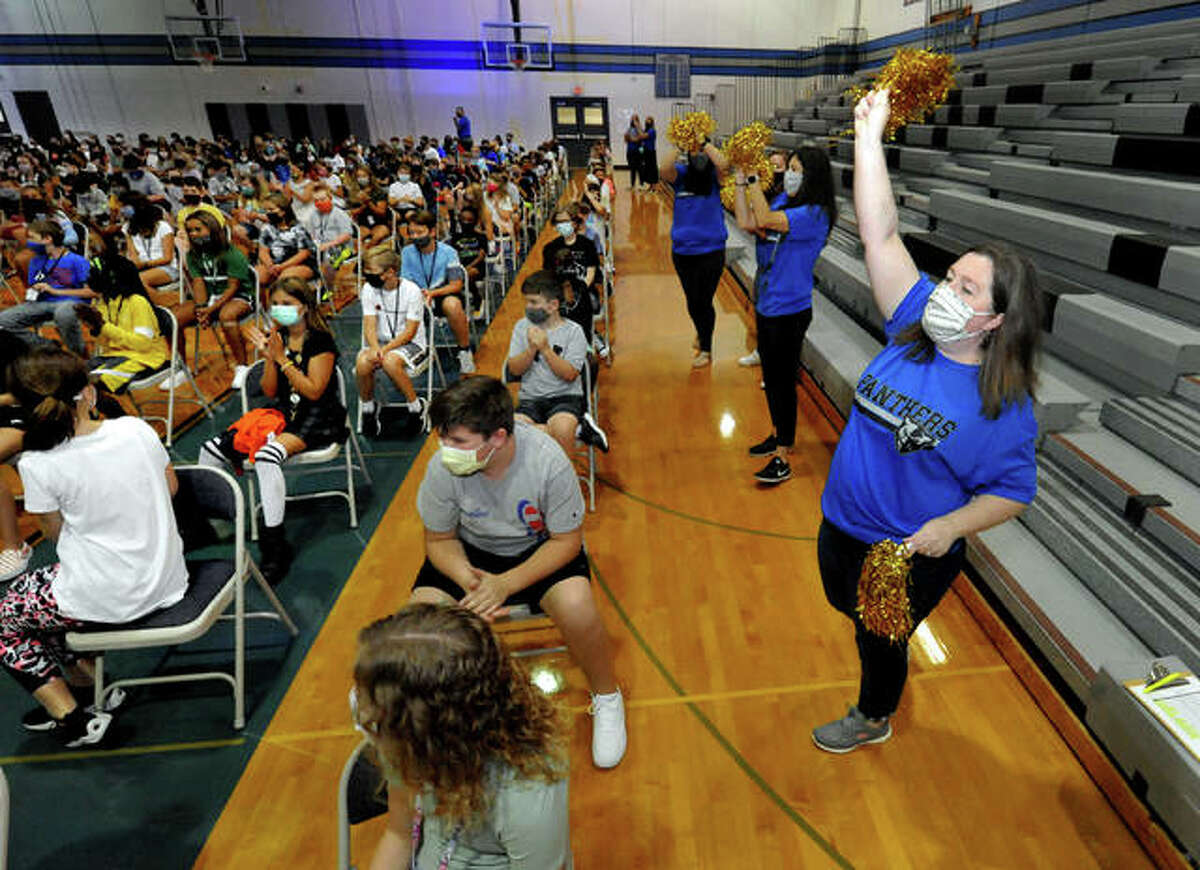 Sixth-grade Liberty Middle School teacher Sarah Hollis, right, whips up the crowd of students with a cheer during a welcome assembly Wednesday.